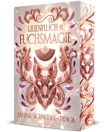 Das altrosafarbene Cover zeigt mittig in Bronze eine Fuchsmaske, darüber den Titel in großen Buchstaben und einen Fächer. Umrandet wird alles von bronzefarbenen Ornamenten und rosa- und lilafarbenen Blütenblättern. Auf dem hellen Farbschnitt sind ebenfalls eine bronzefarbene Fuchsmaske und passende Ornamente.